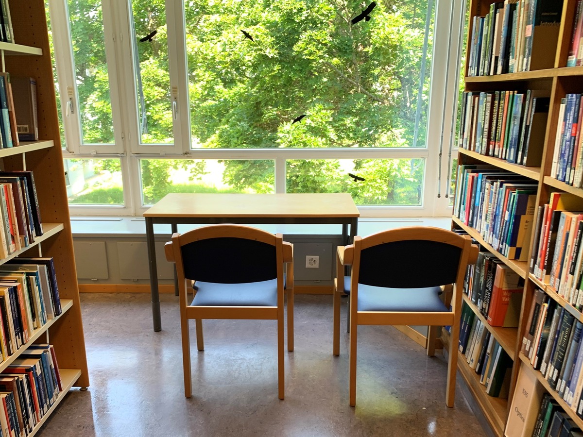 An image of the library with a desk a two chairs.